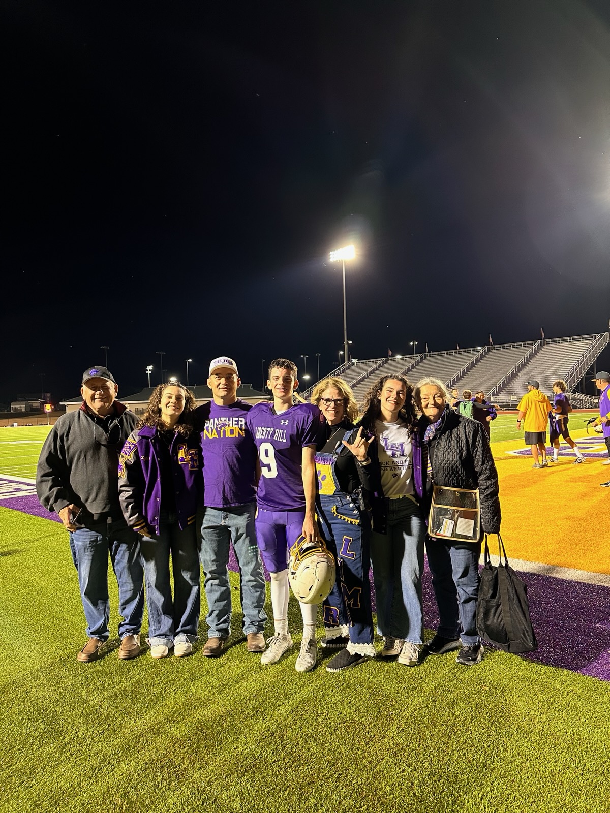 The Miller family together at a Liberty Hill ISD high school football game under the stadium lights