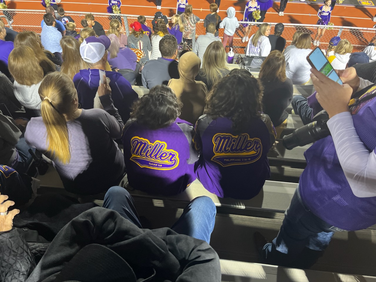 The Miller family in the stands at a Liberty Hill ISD high school football game under the stadium lights